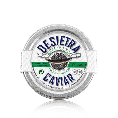  Hand holding a mother of pearl spoon filled with 250g Desietra Baeriskaya kaviaar (baerii), a sustainably farmed caviar without any additives